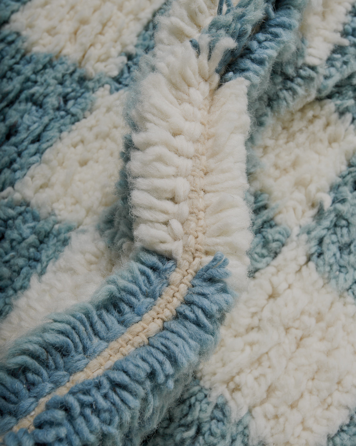 close up of checkered rug in cream and robin's egg blue wool